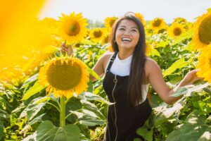 Photo of an Asian American woman smiling while in a field of sunflowers. Break free from your depression symptoms. Meet with a skilled therapist and find support with depression therapy in San Ramon, CA.