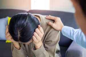 Photo of an Asian woman sitting on a couch talking to a depression therapist. This photo represents how depresison therapy in San Ramon, CA can help you learn coping skills to face your depression symptoms.