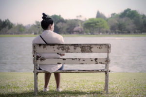 Photo of a woman sitting on a bench looking out at a lake.Have your anxiety symptoms gotten out of control? Learn what types of anxiety there is from an anxiety therapist in California here.