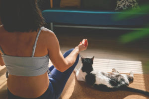 Photo of a woman sitting on the floor with her cat practicing meditation . This photo represents the skills you can learn in anxiety therapy in San Ramon, CA to help you cope with your anxiety.