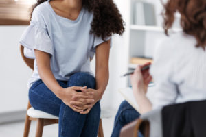 Photo of a woman sitting down and speaking with a depression therapist. Discover how a depression therapist in California can help you start to manage your depression symptoms and begin your healing journey.