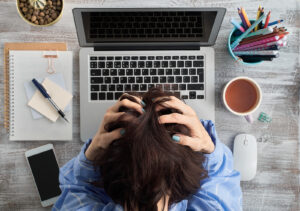 A woman bows her head while sitting in front of her laptop. This could represent the stress of layoffs that anxiety therapy in san ramon, ca can offer. Search for an online anxiety therapist in California to learn more about anxiety therapy in california. 
